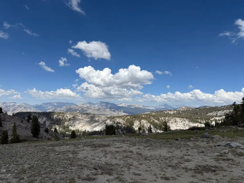 A view of the Sierra High Country from a high vantage, showing clouds, peaks and valleys.