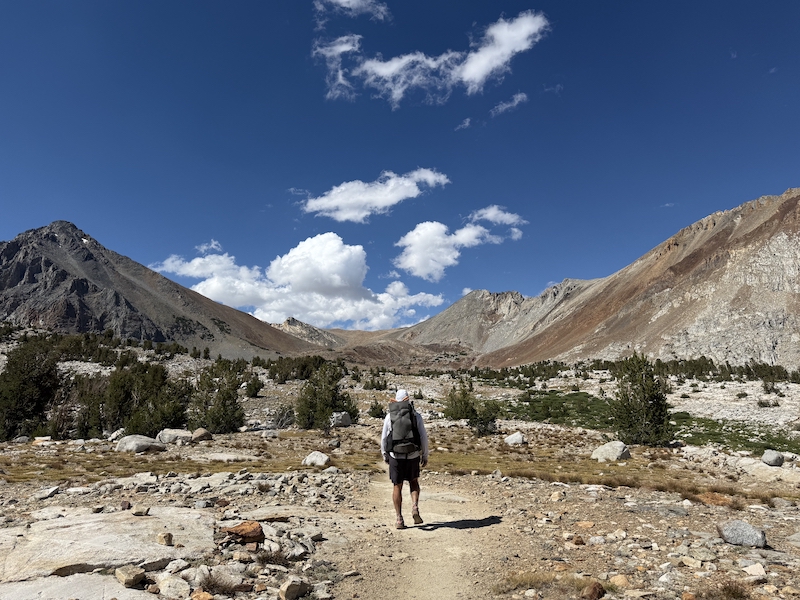 Hiker walking through mountainous landscape in Yosemite National Park